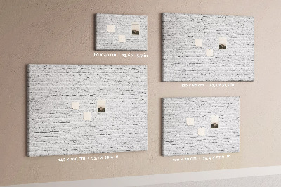 Korktafel mit weißem Backsteinmauer-Motiv und bunten Reißzwecken