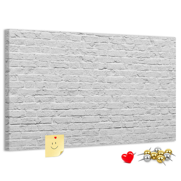 Korktafel mit weißem Backsteinmauer-Motiv und bunten Reißzwecken