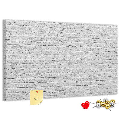 Korktafel mit weißem Backsteinmauer-Motiv und bunten Reißzwecken