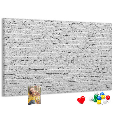 Korktafel mit weißem Backsteinmauer-Motiv und bunten Reißzwecken