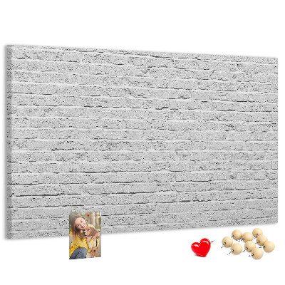Korktafel mit weißem Backsteinmauer-Motiv und bunten Reißzwecken