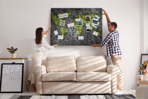 Korktafel mit grüner Weltkarte auf grauem Hintergrund