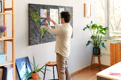 Korktafel mit grüner Weltkarte auf grauem Hintergrund